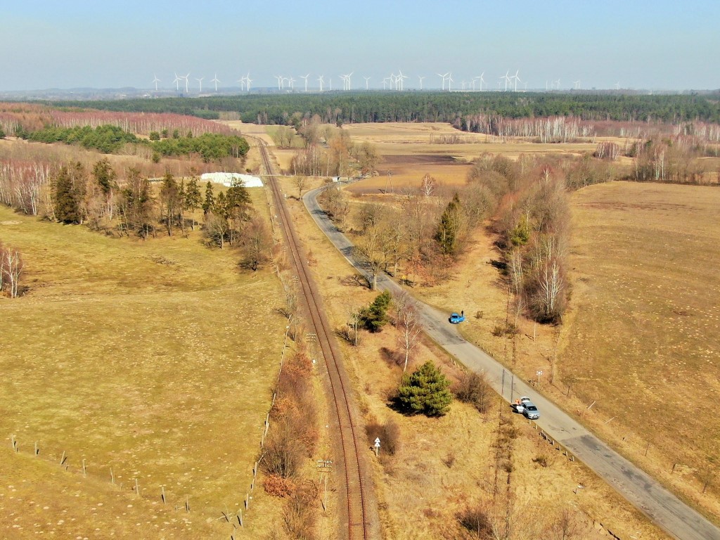 Tory na linii Lębork - Łeba, w tle elektrownia wiatrowa (fot. Szymon Danielek / PKP PLK)