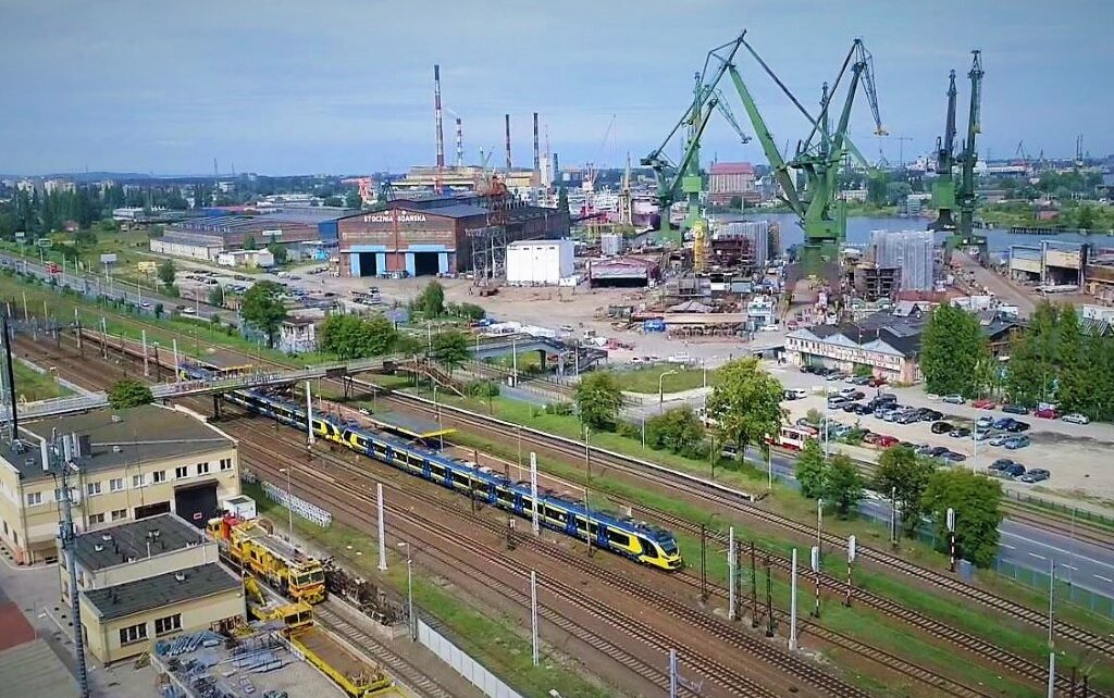 Pociąg SKM Trójmiasto na tle stoczni (fot. SKM Trójmiasto / archiwum)